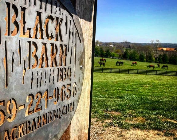 Black Barn BBQ sign and field